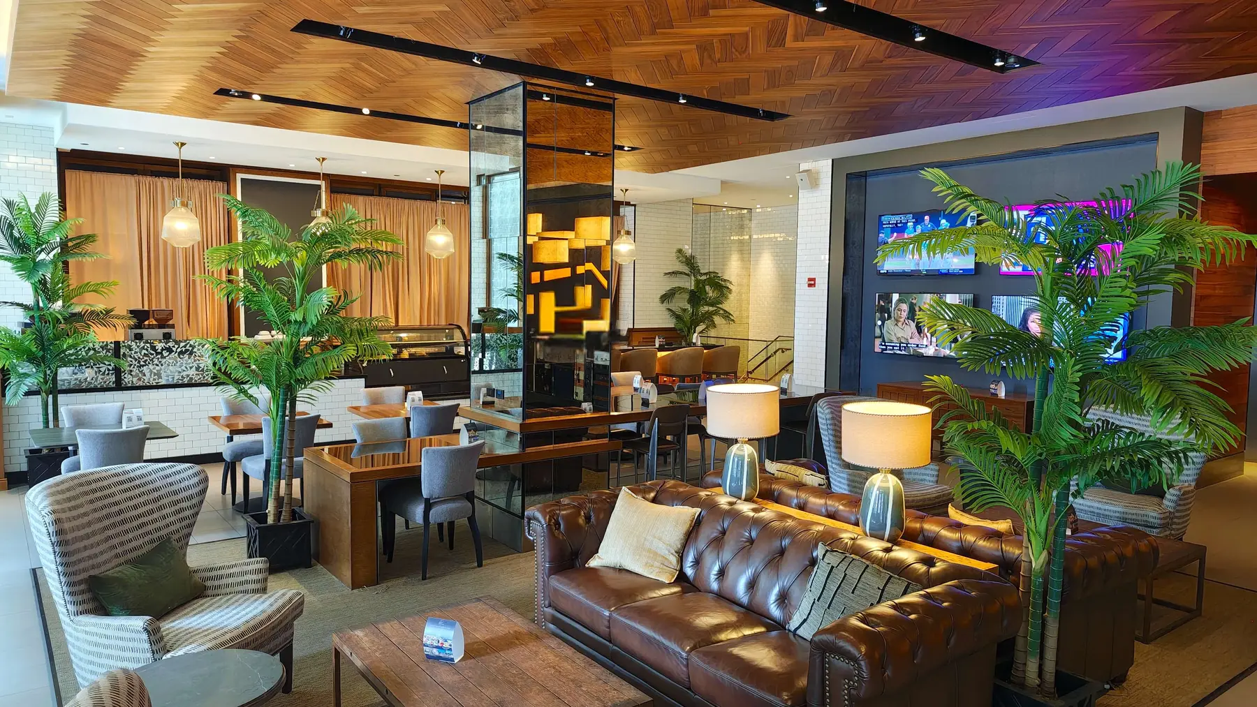 A second view of the Magnificent Mile lounge with leather sofas, dining seating and warm wood ceilings